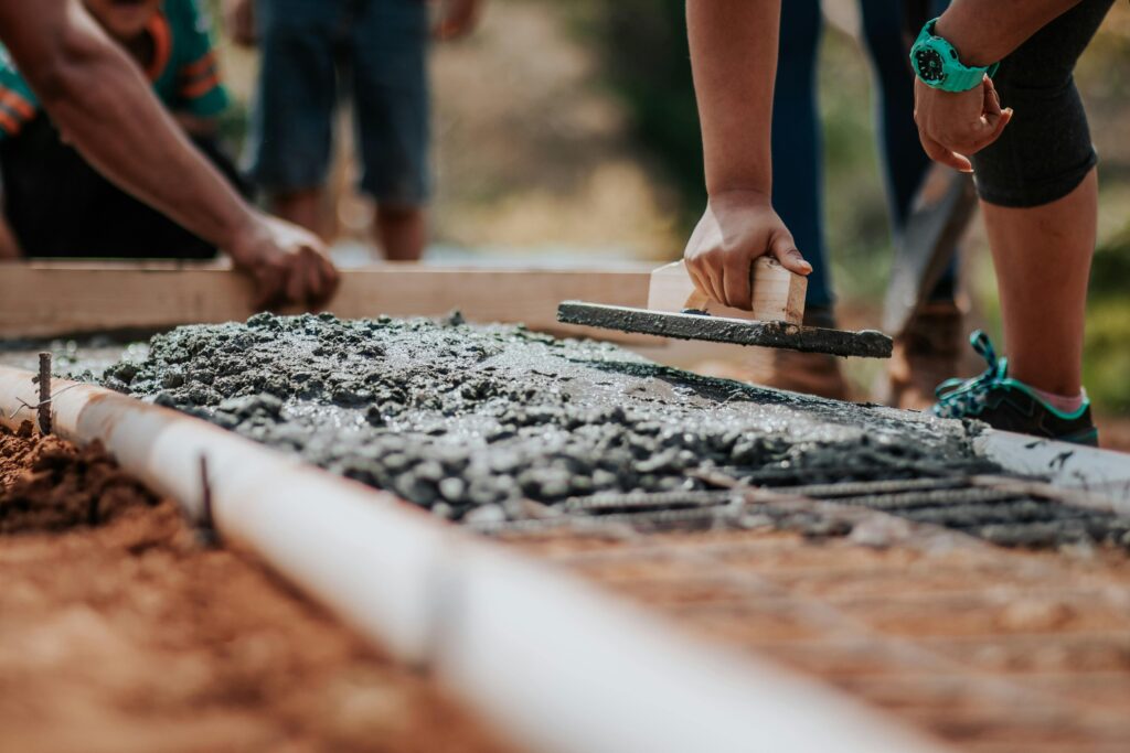 pexels photo 2219024 2219024 Construction workers leveling fresh cement on a sunny day at an outdoor site.